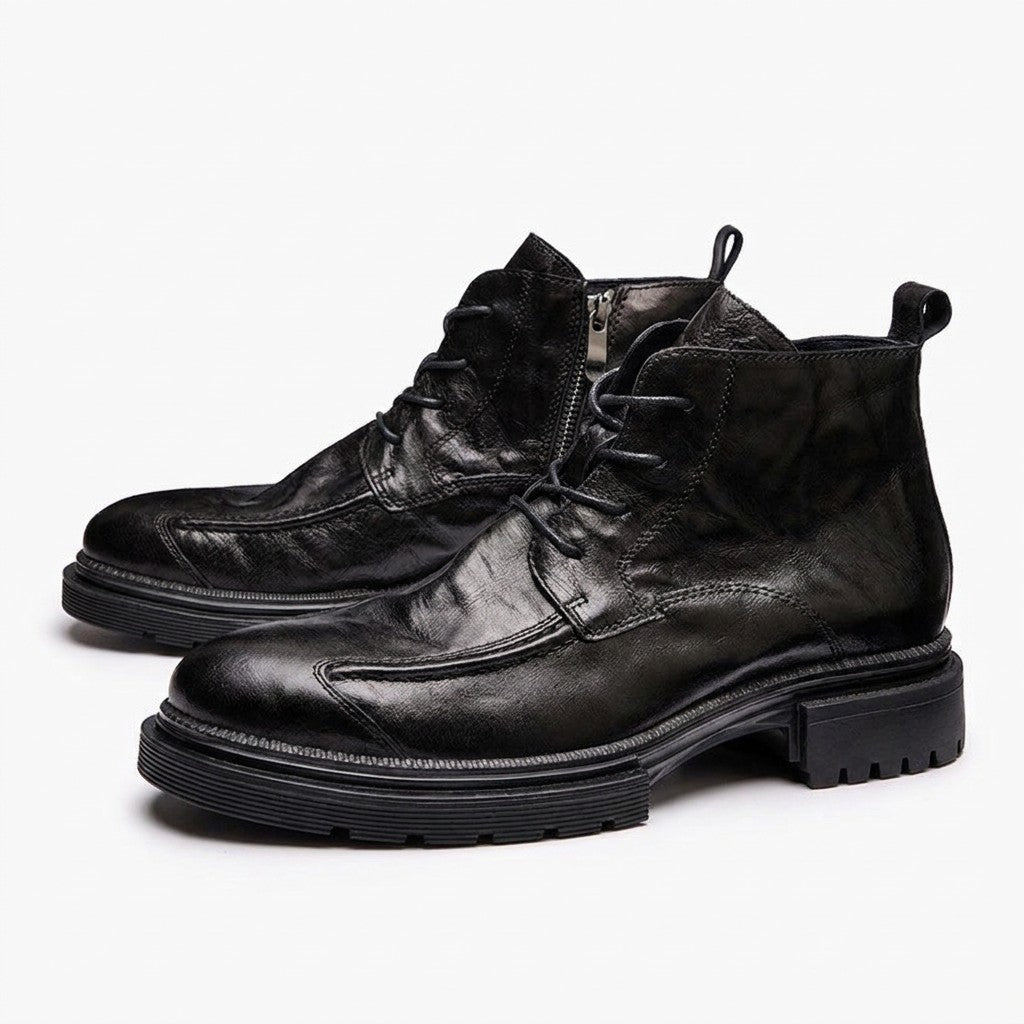 Pair of black Nils men's leather lace-up ankle boots on white, side view with chunky lug sole