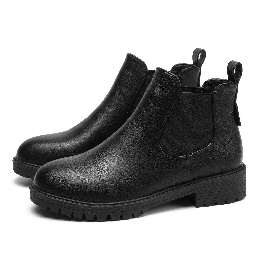 Pair of black Ines leather Chelsea boots on white, side view with chunky cleated sole