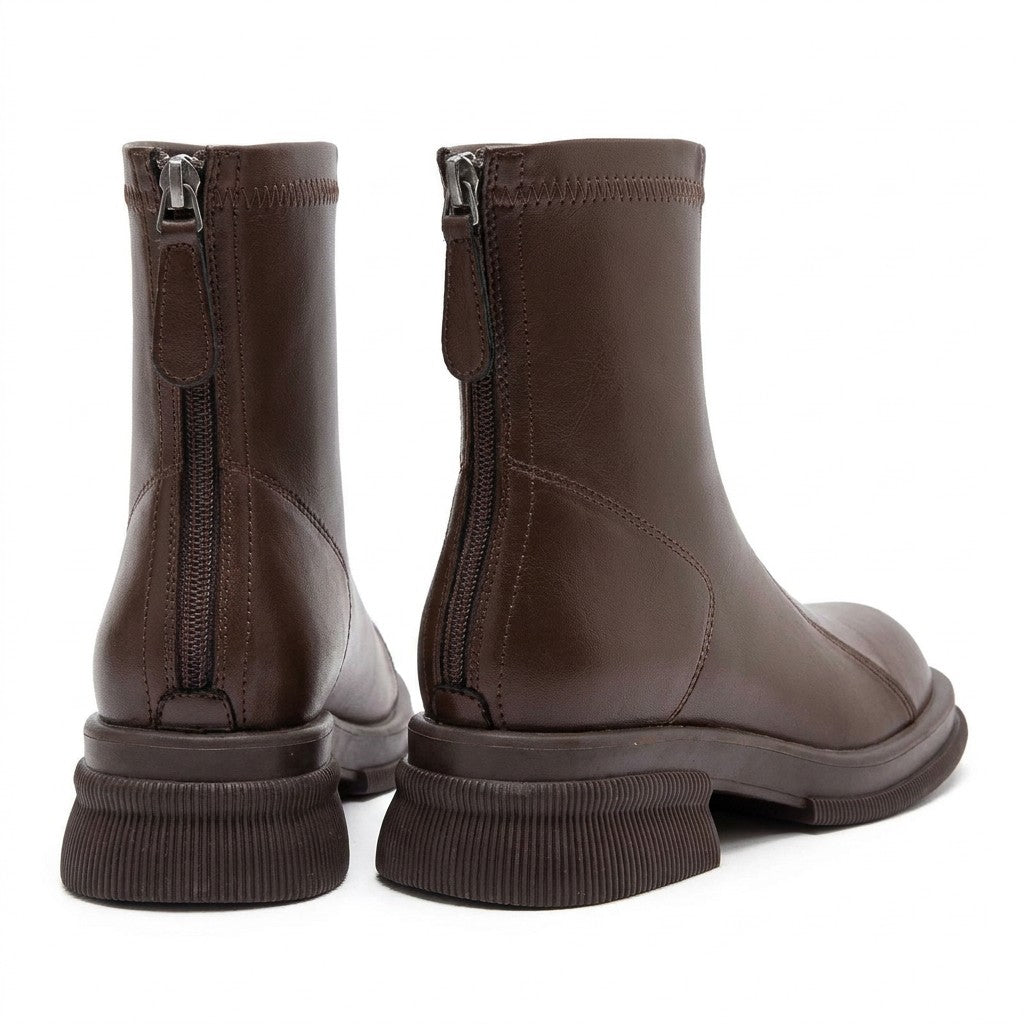 Brown Liesel ankle boots from behind on white, showing centre-back zips and ribbed heels