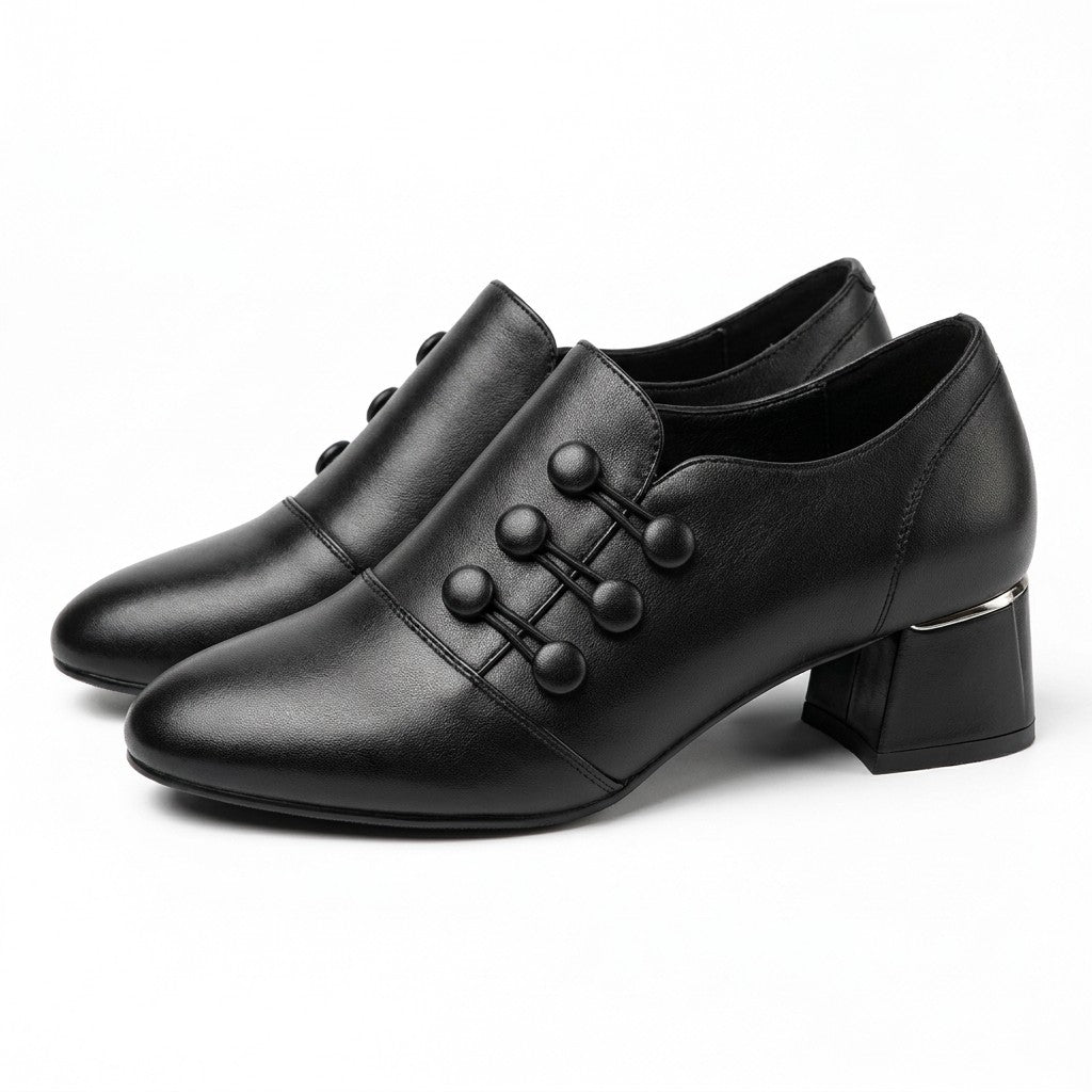 Pair of black Clemence leather shoe boots with corded buttons, side view on white