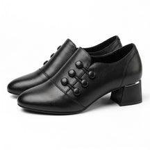 Pair of black Clemence leather shoe boots with corded buttons, side view on white
