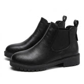 Pair of black Ines leather Chelsea boots on white, side view with chunky cleated sole