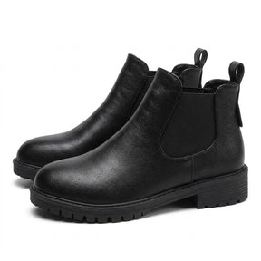 Pair of black Ines leather Chelsea boots on white, side view with chunky cleated sole