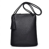 Front view of the black Solveig leather crossbody bag with tassel and cord strap on white
