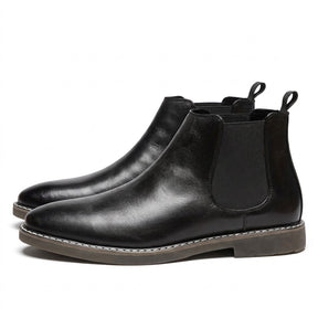 Pair of black Falk men's leather Chelsea boots on white, side view