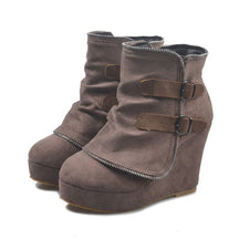 Pair of taupe Saskia suede wedge ankle boots on white, outer side with two buckled straps