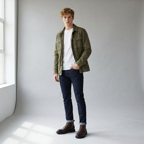 Model wearing brown Nils lace-up boots with turned-up indigo jeans and an olive field jacket