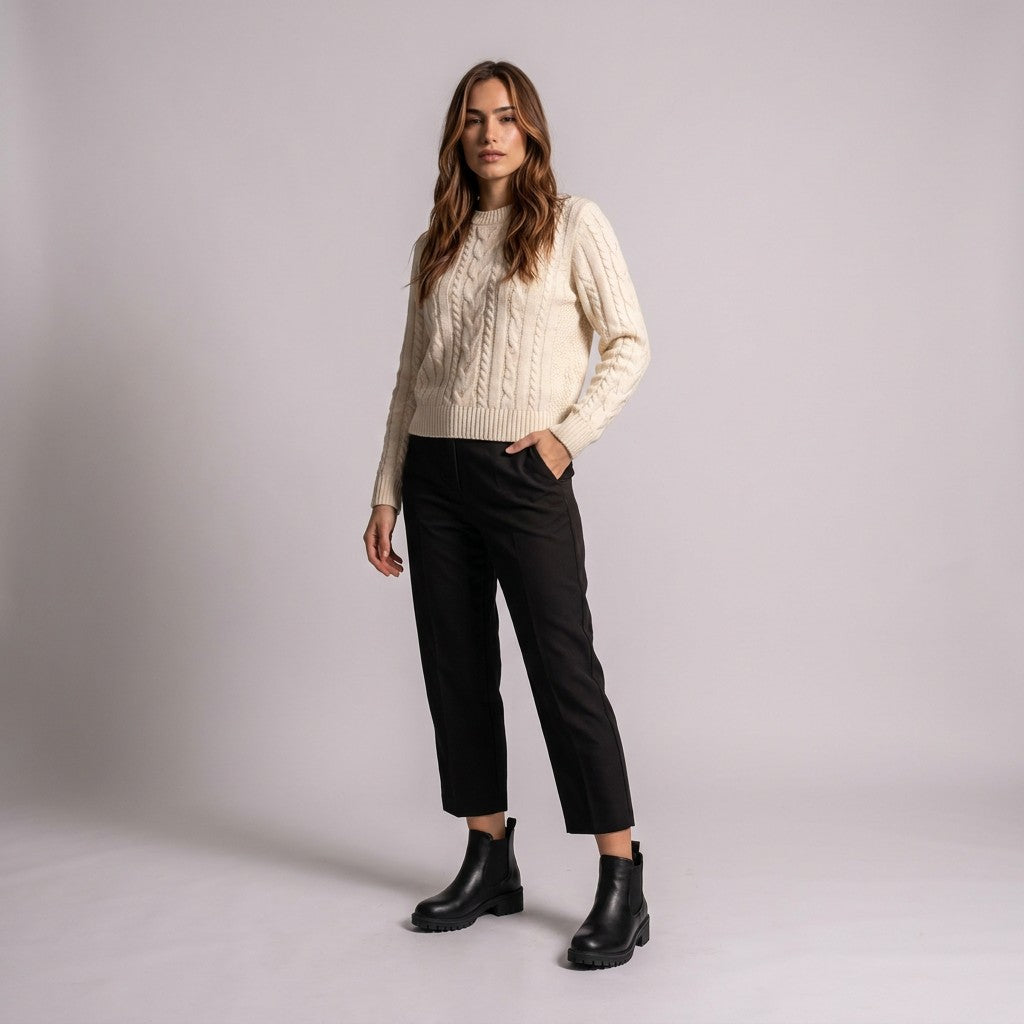 Model wearing black Ines Chelsea boots with cropped black trousers and a cream cable-knit jumper