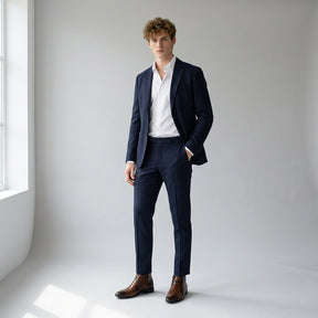 Model in a navy suit and open-collar white shirt wearing brown Ivo dress boots