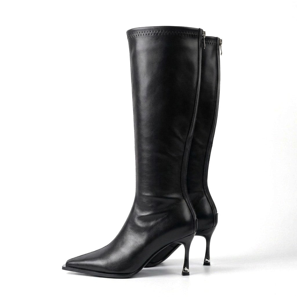 Pair of black Maribel leather knee high boots with pointed toes and silver heel tips on white