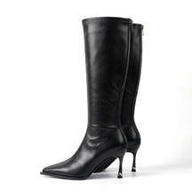 Pair of black Maribel leather knee high boots with pointed toes and silver heel tips on white