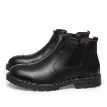 Pair of black Henrik Chelsea boots on white with front strap loop and white welt stitching