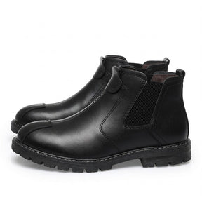 Pair of black Henrik Chelsea boots on white with front strap loop and white welt stitching