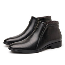 Pair of black polished Ivo dress ankle boots on white with pointed toe and V chevron