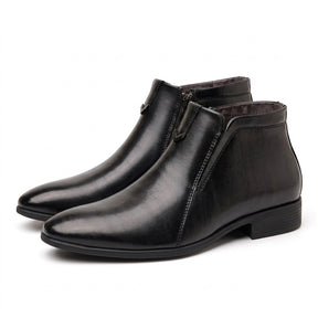 Pair of black polished Ivo dress ankle boots on white with pointed toe and V chevron