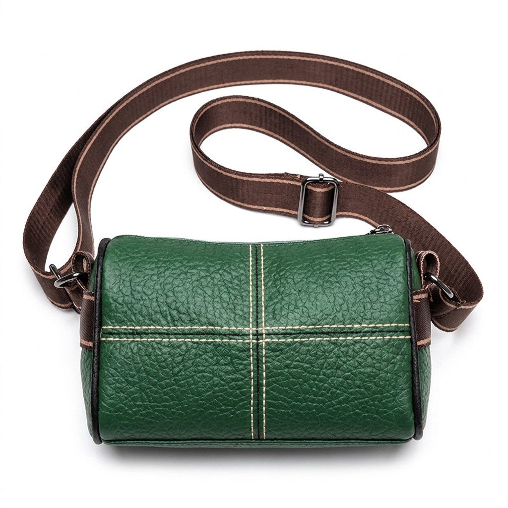 Emerald green Bellamy leather barrel bag with cream topstitching and black piping on white