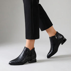 Tamsin ankle boots worn mid-stride, showing the outer bow and the inner side zip