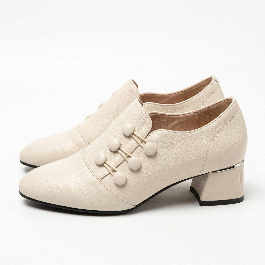 Pair of cream Clemence leather shoe boots with button detail on white