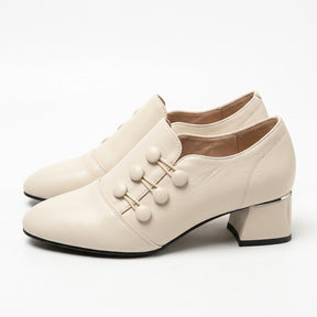 Pair of cream Clemence leather shoe boots with button detail on white