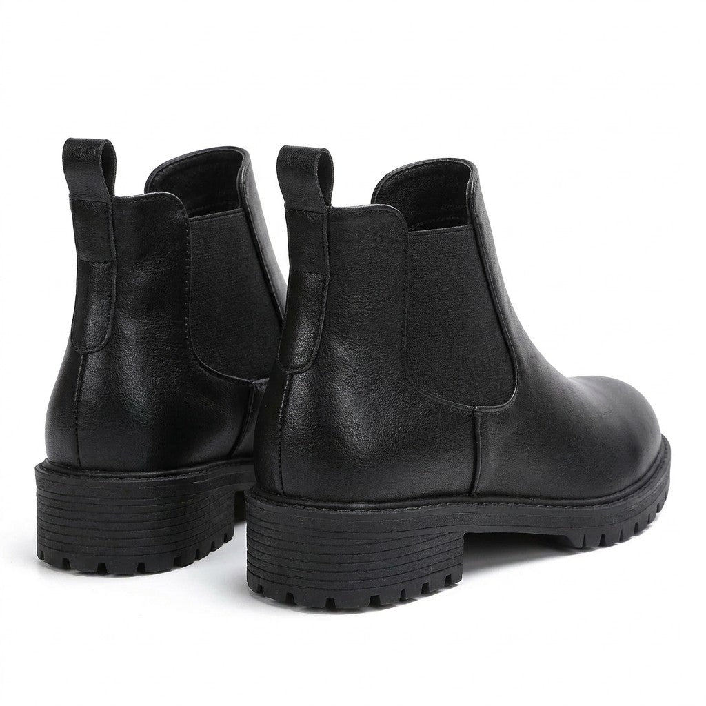 Ines black Chelsea boots from behind on white, back pull loops and lugged heels