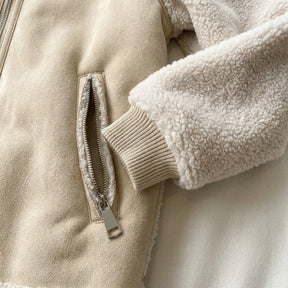 Close-up of the Fenna zip pocket with shearling piping and the rib-knit cuff under the shearling sleeve