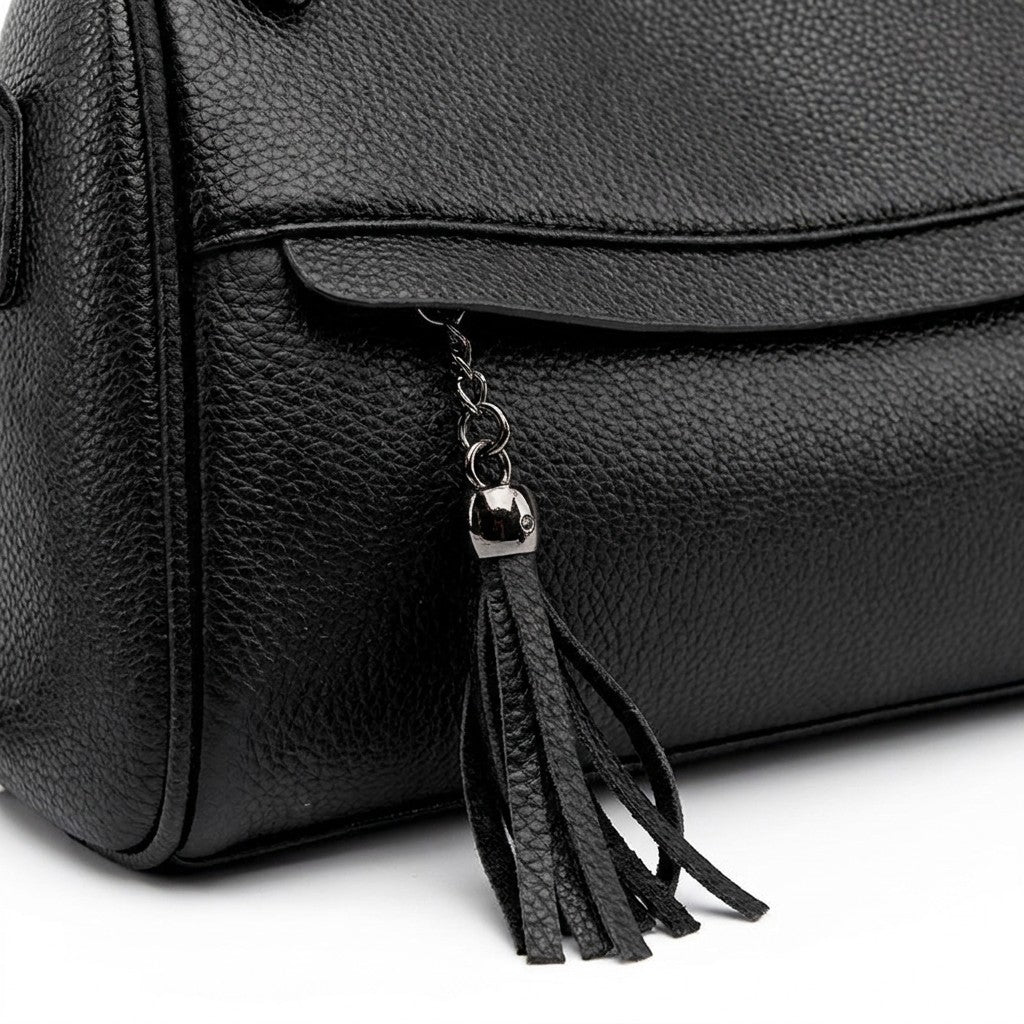 Close-up of the fringed black leather tassel and gunmetal cap on the Odalys front zip pocket