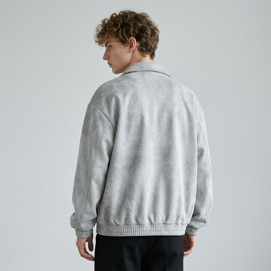 Back view of the grey Emeric jacket on a model, plain back and gathered blouson hem