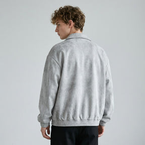Back view of the grey Emeric jacket on a model, plain back and gathered blouson hem