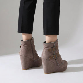 Rear three-quarter view of taupe Saskia boots showing the inner zip and high suede wedge