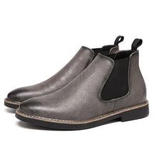 Pair of grey Falk Chelsea boots with black elastic panels on white