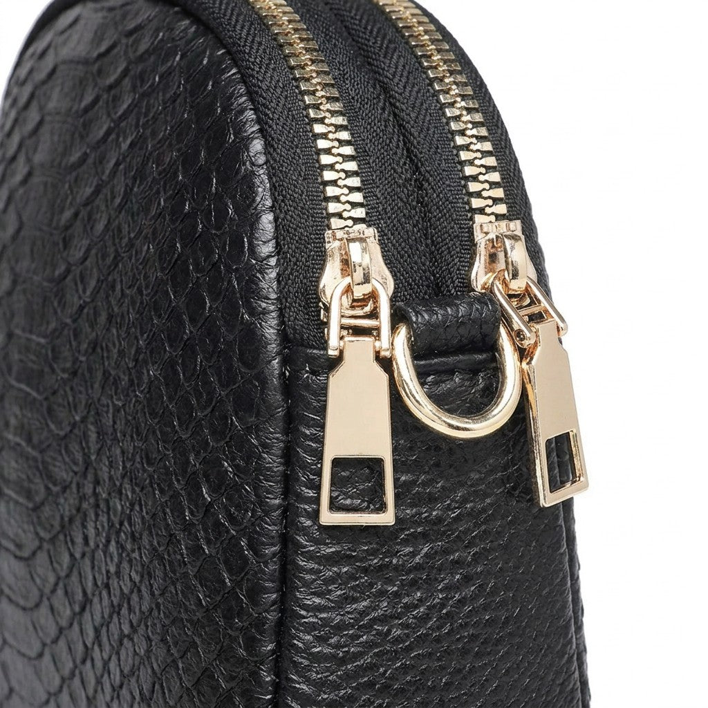 Close-up of the twin gold-tone zips, rectangular zip pulls and D-ring on the Isaure