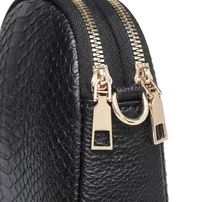 Close-up of the twin gold-tone zips, rectangular zip pulls and D-ring on the Isaure
