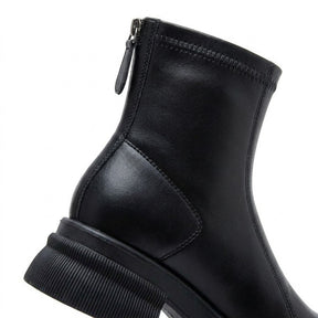 Close-up of the Liesel back zip pull tab, zigzag-stitched top band and ribbed block heel