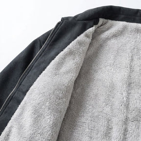 Close-up of the plush fleece lining inside the black Emeric jacket beside the metal zip