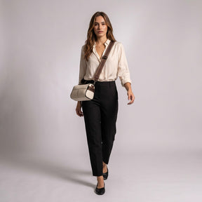 Model walking in the studio wearing the cream Bellamy bag crossbody