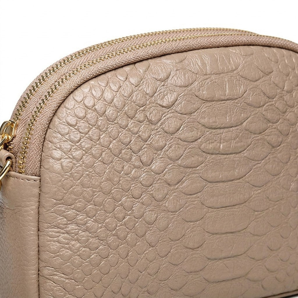 Macro of the croc-embossed scale texture on the beige Isaure front panel
